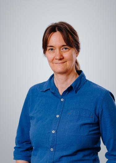 A woman in a blue shirt who smiles 
