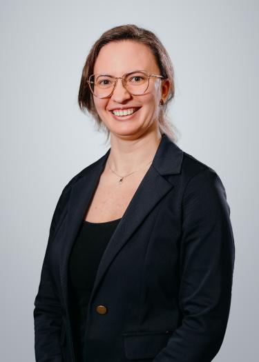 A portrait of a woman with glasses who smiles